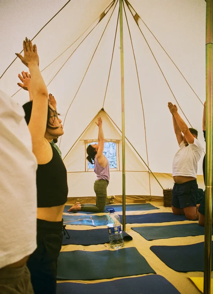 GRIANGHRAIF YOGA - EOIN - 27 (3) Éalú Aran-min Participants engaged in a yoga session inside a spacious tent at Éalú Aran's wellness retreat on Inis Oírr, promoting relaxation and connection with nature.