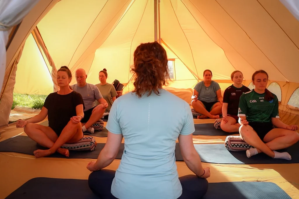 1G4A9179.00_00_48_12.Still006 Áine Seoighe Participants engage in a guided meditation session during an Éalú Aran wellness retreat, surrounded by the serene atmosphere of a glamping tent on Inis Oírr.